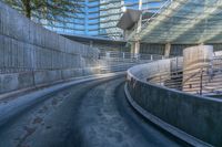 a curved metal rail and a walkway in between the concrete walls of an indoor arena