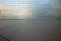 the man is on his skateboard near the building outside the wall of the building