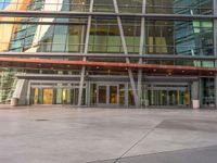 the people walking past a building have large windows at it's sides and doors