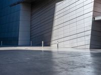 a man riding a skateboard in the middle of cement area next to a building