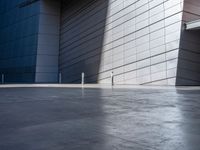 a man riding a skateboard in the middle of cement area next to a building