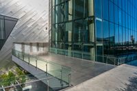 the building has glass windows with an enclosed balcony that overlooks a park next to it