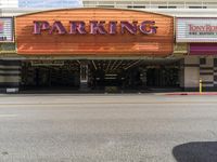 there is an orange sign that says parking at the entrance to a movie theater tower