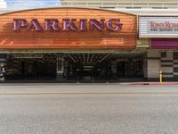 there is an orange sign that says parking at the entrance to a movie theater tower