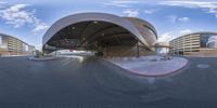 a small parking garage is featured in the foreground in this time lapse fisheye photograph