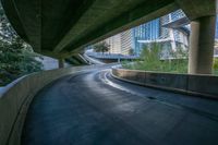 an overpass of a freeway in a city with tall buildings and blue sky in the background