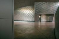 the large building has metallic cladding and a stone floor with light streams passing through