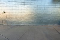 a skateboarder is jumping up in the air in front of a brick wall