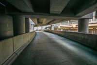 a long empty street lined with concrete pillars and walkways in an urban city area