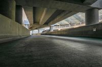 a long empty street lined with concrete pillars and walkways in an urban city area