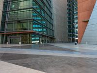 a man in uniform on top of an asphalt floor next to a building with glass walls