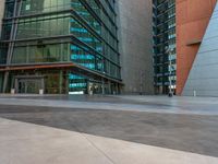 a man in uniform on top of an asphalt floor next to a building with glass walls