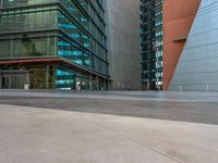 a man in uniform on top of an asphalt floor next to a building with glass walls