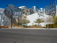 the building has silver and black tiles on it's sides, with windows and a metal structure at one side