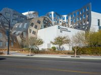 the building has silver and black tiles on it's sides, with windows and a metal structure at one side