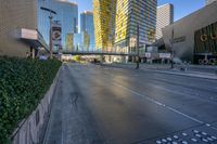 people are walking and biking on the street outside a modern city center with large buildings on either side