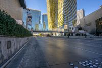 people are walking and biking on the street outside a modern city center with large buildings on either side