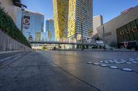 people are walking and biking on the street outside a modern city center with large buildings on either side