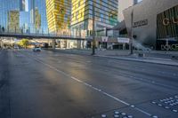 people are walking and biking on the street outside a modern city center with large buildings on either side