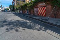 a empty street next to several tall brick buildings with green vines on it's side