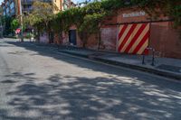 a empty street next to several tall brick buildings with green vines on it's side