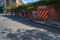 a empty street next to several tall brick buildings with green vines on it's side