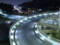 a city view at night shows a freeway going over the cliff tops and light up buildings