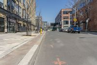 the cars are lined up on this city street in front of a building with many windows