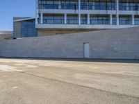 an older man is skateboarding down a slope outside of a large building while the sun shines down on him