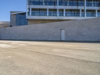 an older man is skateboarding down a slope outside of a large building while the sun shines down on him