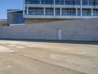 an older man is skateboarding down a slope outside of a large building while the sun shines down on him