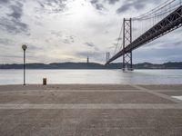 the view of a bridge from across the water to a beach, with a large island in