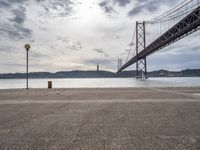 the view of a bridge from across the water to a beach, with a large island in