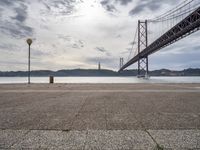 the view of a bridge from across the water to a beach, with a large island in