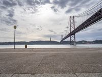 the view of a bridge from across the water to a beach, with a large island in