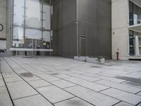 an entrance and window in a building with tiled flooring and glass walls, looking at the outside