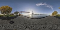 a wide angle view of a bridge in the distance and a path by a body of water