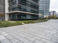 the sidewalk in front of some buildings with a clock on it on the side of a building