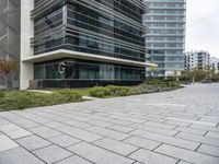 the sidewalk in front of some buildings with a clock on it on the side of a building