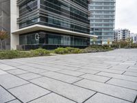 the sidewalk in front of some buildings with a clock on it on the side of a building