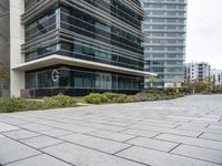 the sidewalk in front of some buildings with a clock on it on the side of a building