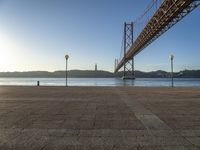 the bridge spans over to another island with the sun on it's horizon in view