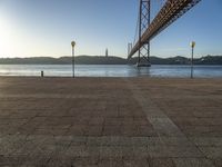 the bridge spans over to another island with the sun on it's horizon in view