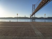 the bridge spans over to another island with the sun on it's horizon in view