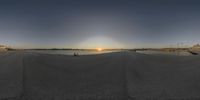 a view of a beach from a boat ramp at sunrise, looking like a panorama of the sunsets