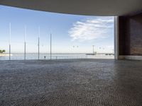 a view down a brick walkway with light poles on either side and in the background, a bright blue sky