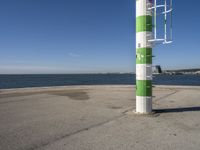 a street light next to a body of water on the beach side near a pier