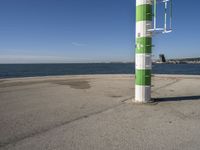 a street light next to a body of water on the beach side near a pier