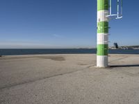 a street light next to a body of water on the beach side near a pier