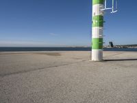 a street light next to a body of water on the beach side near a pier